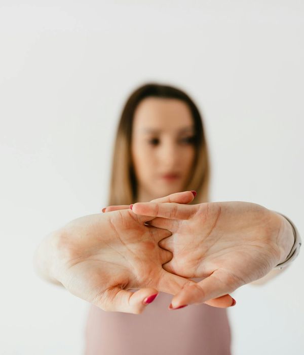 Woman performing a gentle stretching movement in a calm setting.